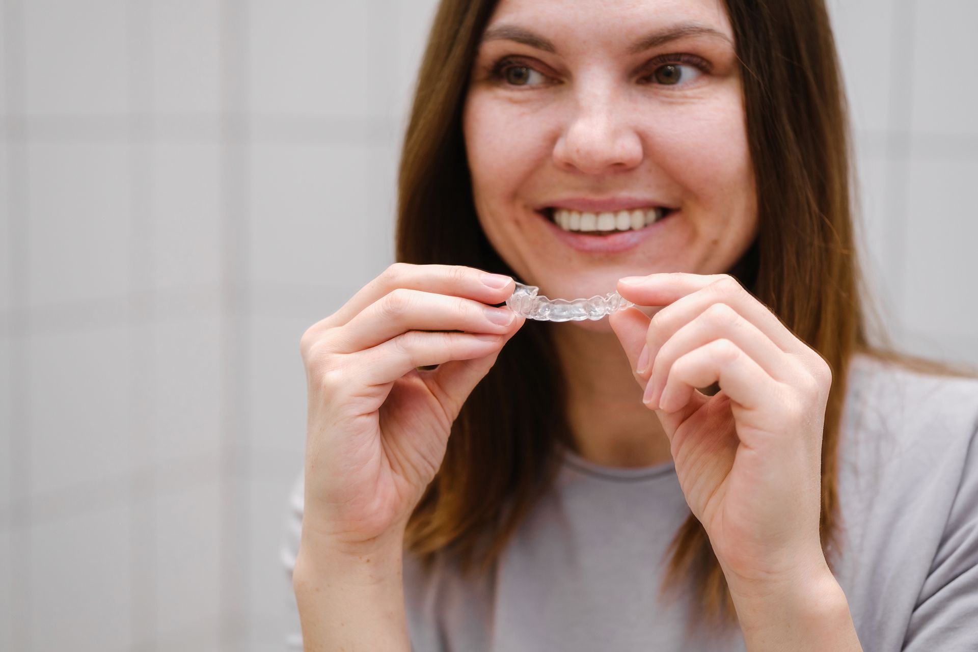 A woman is brushing her teeth in front of a mirror