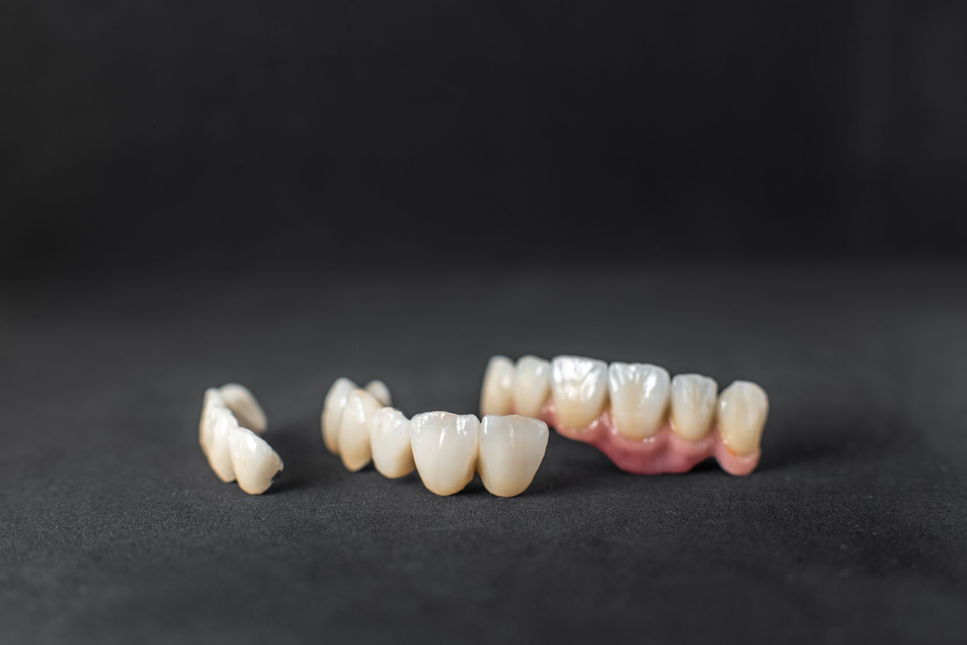 Dentures and loose artificial teeth on a dark surface