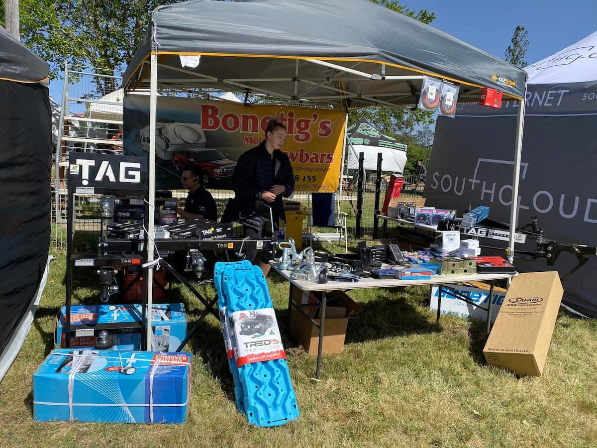 A Man Is Standing Behind a Table Under a Tent — Bonetig's Mobile Towbars & Trailers In Oak Flats, NSW
