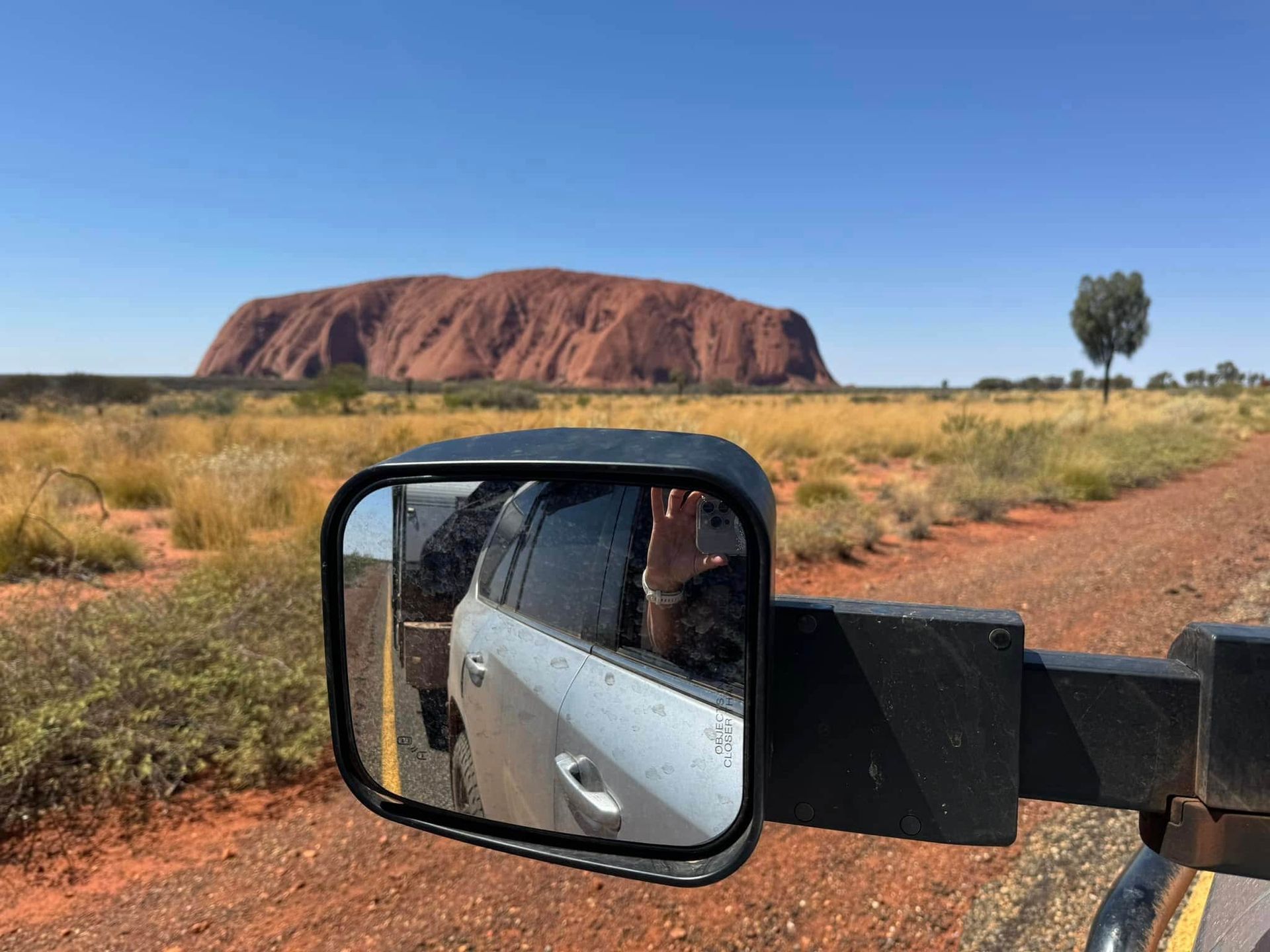 A Car Is Driving Down a Dirt Road with A Mountain in The Background — Bonetig's Mobile Towbars & Trailers In Oak Flats, NSW
