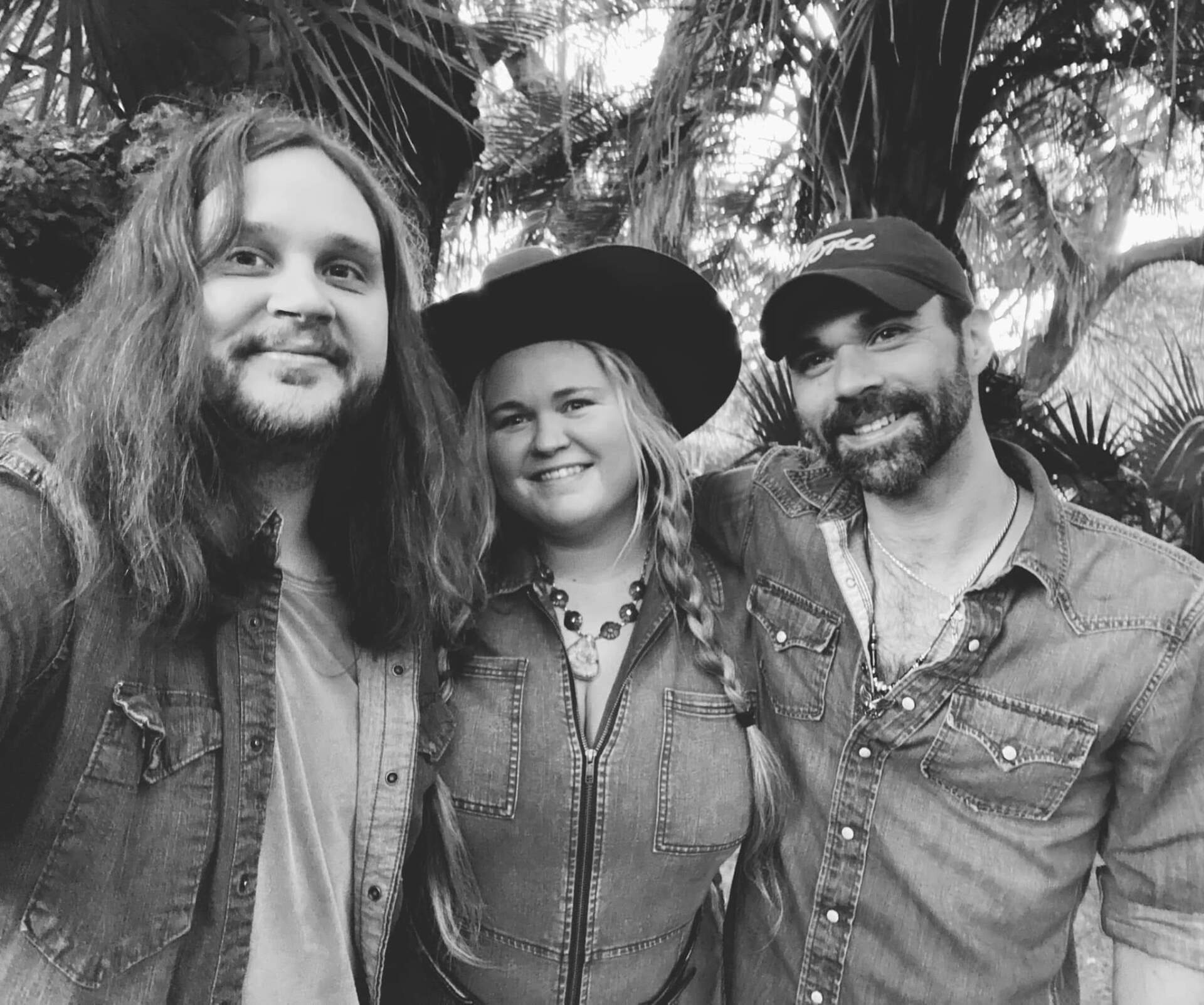A black and white photo of three people posing for a picture.