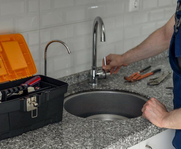Plumber Checking the Faucet — Albuquerque, NM — Donner Plumbing & Heating