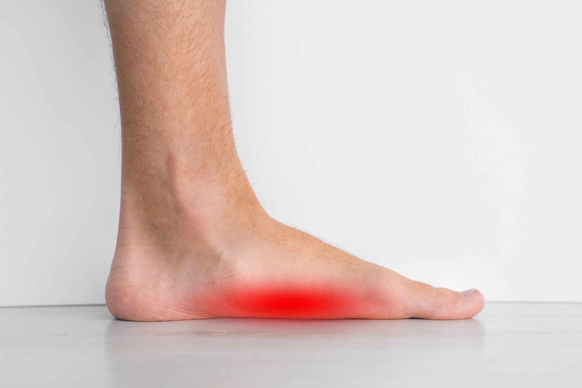 Bare foot with red highlighting on the arch, possibly indicating pain or inflammation.