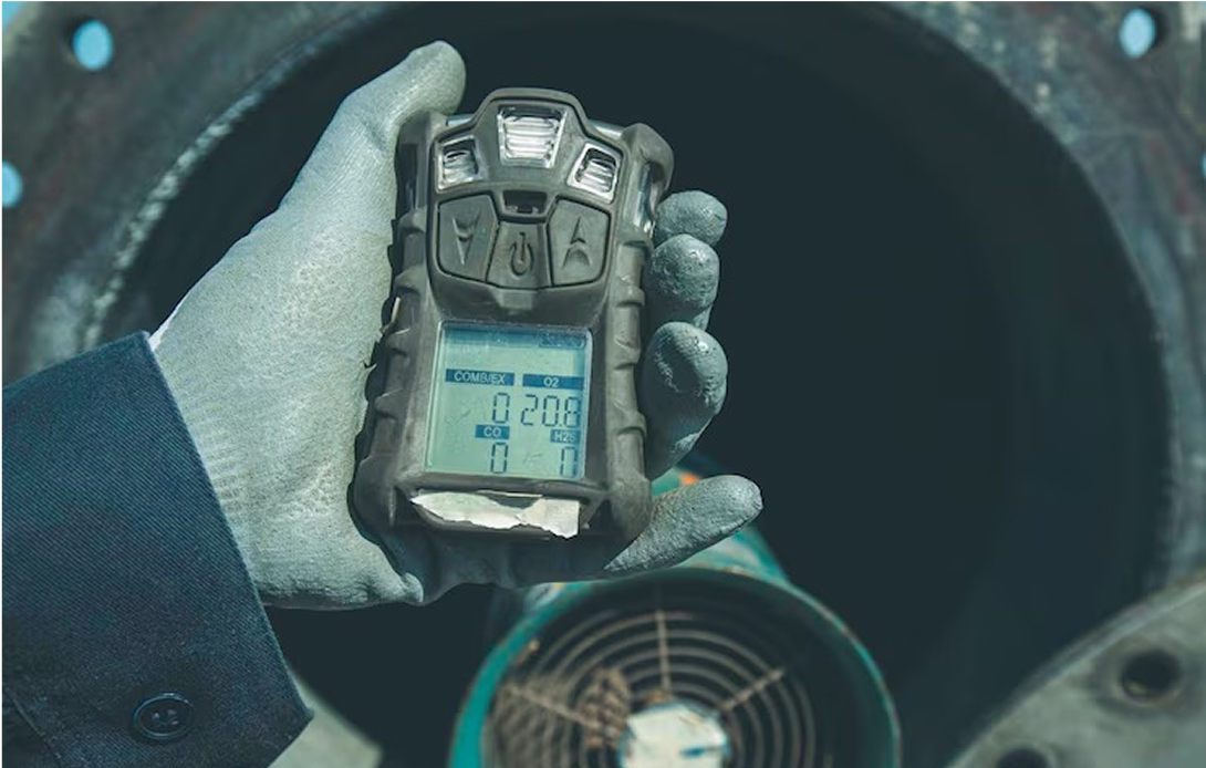A person is holding a gas detector in their hand