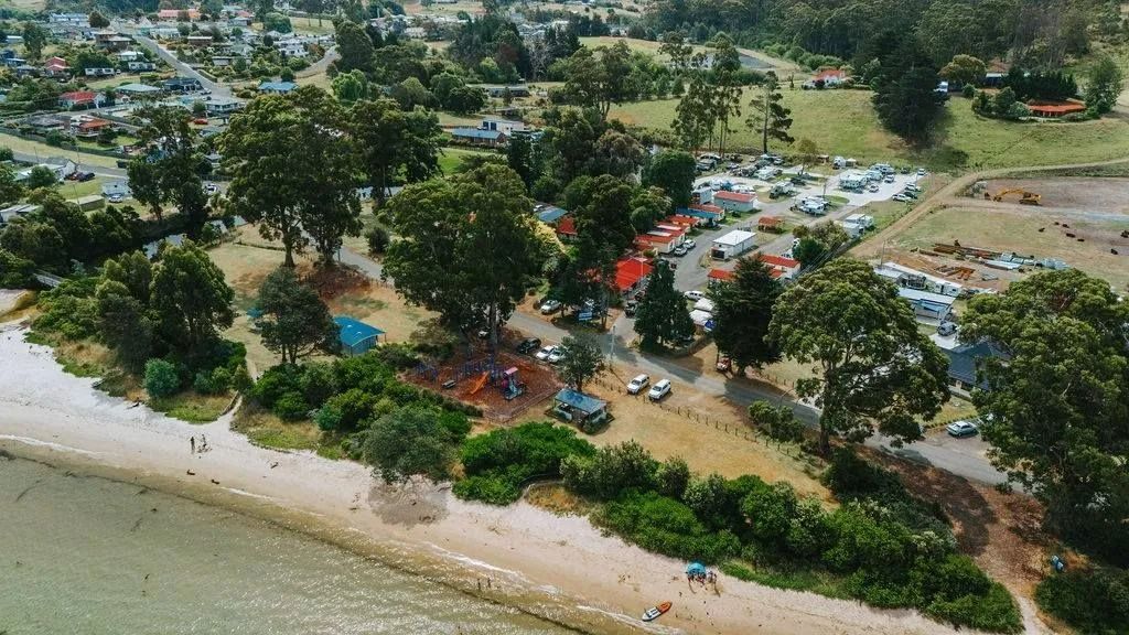 Aerial View Of A Beachside Park With Trees, Parking Area And Camping Site — Dover Caravan Park in Dover, TAS