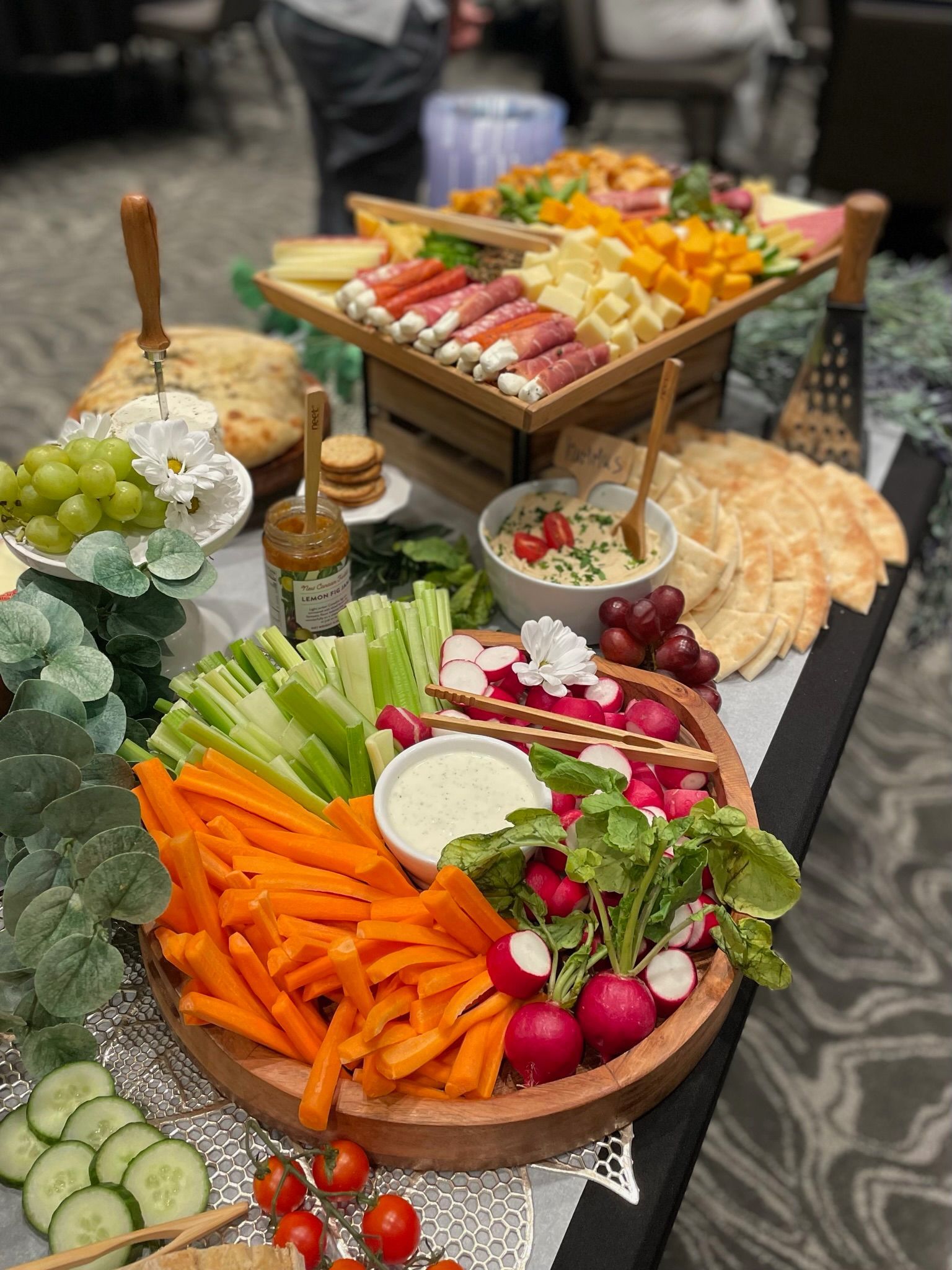 Assorted fresh vegetables and fruit arranged on platters at a buffet table