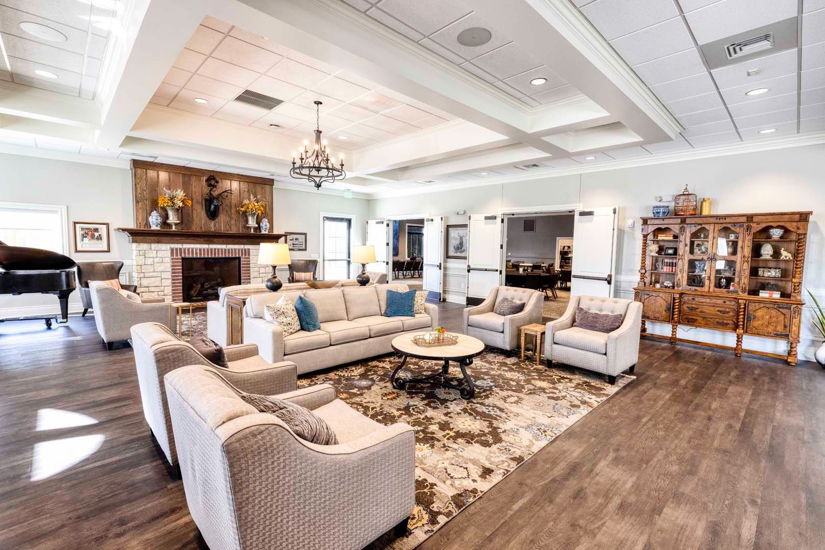 Spacious living room with cream sofas, patterned rug, chandelier, fireplace, and wood flooring