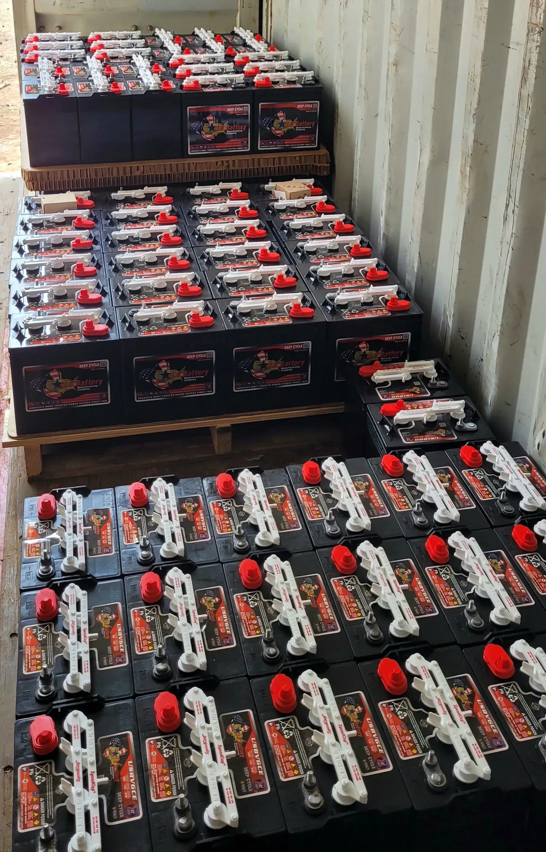 A bunch of batteries are stacked on top of each other in a container.