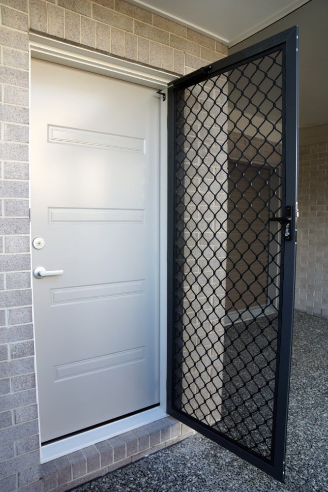 A White Door With A Black Screen Is Open To A Brick Wall — Budget Home Improvements In Tweed Heads South, NSW