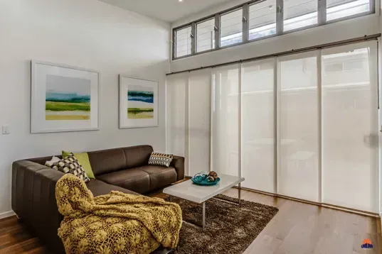 Panel Glide Blinds - Tweed Heads, NSW A living room with a brown couch and a white coffee table - Tweed Heads, NSW