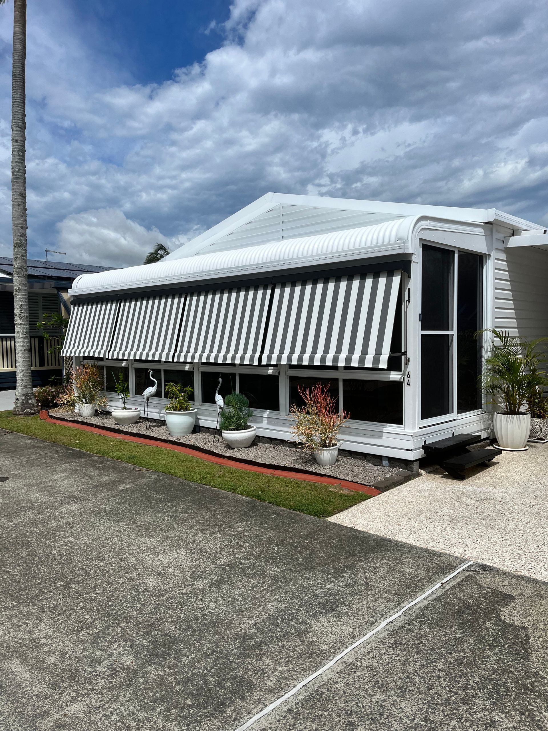 A White Awning Is Hanging From The Side Of A Building — Budget Home Improvements In Tweed Heads South, NSW