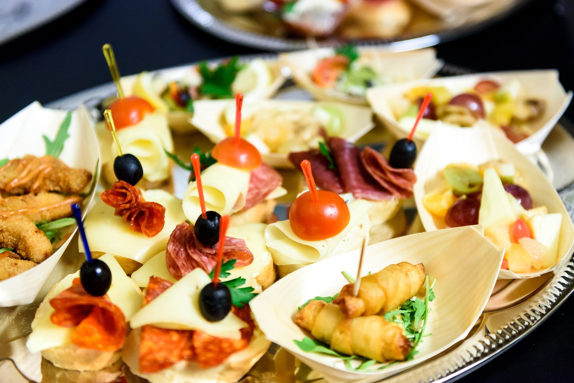 A platter filled with assorted appetisers, including cheese, olives, and crackers, displayed on a table