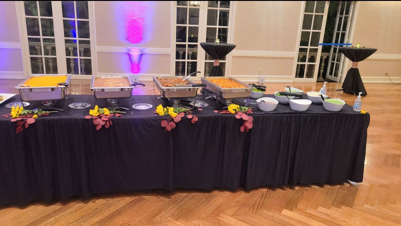 A long buffet table with lots of food on it in a room.