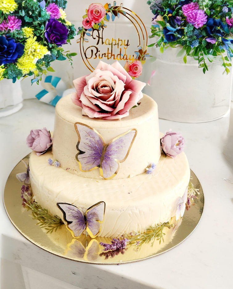 A birthday cake with a rose and butterflies on it
