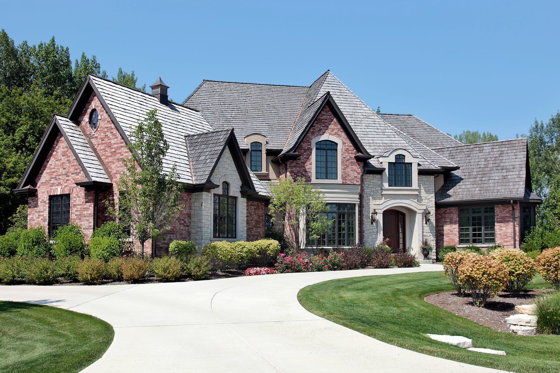 A large brick house with a driveway in front of it