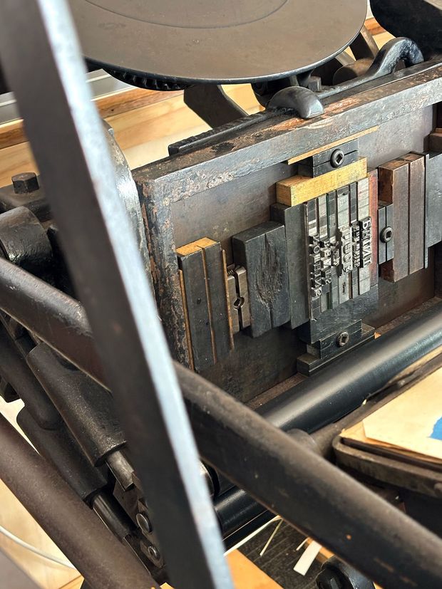 Close-up of a Chandler and Price letterpress printer with typeset type in the chase.
