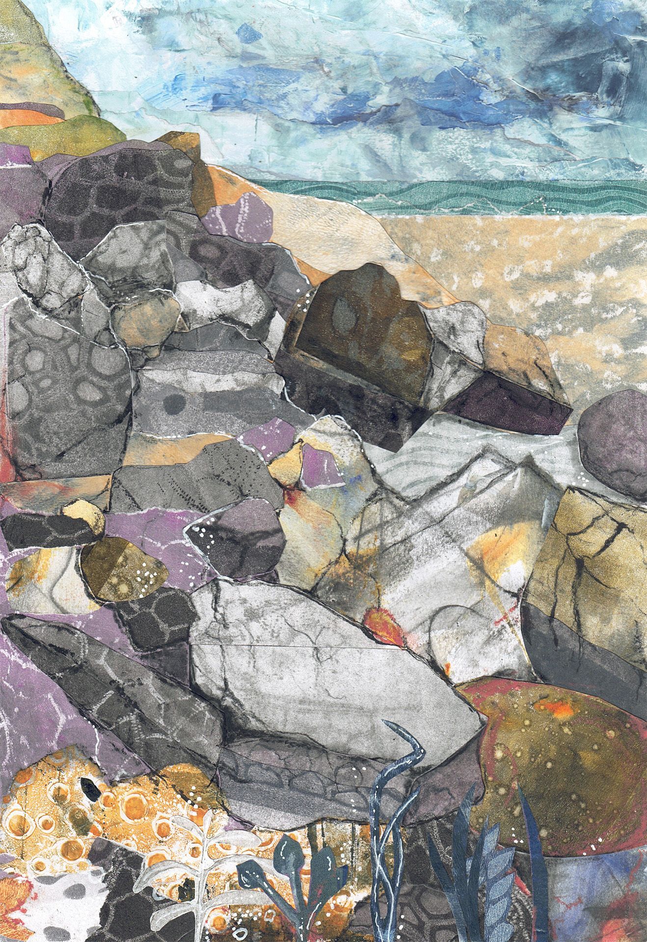 Rocky shoreline with large boulders, sandy beach, and a cloudy blue sea sky.