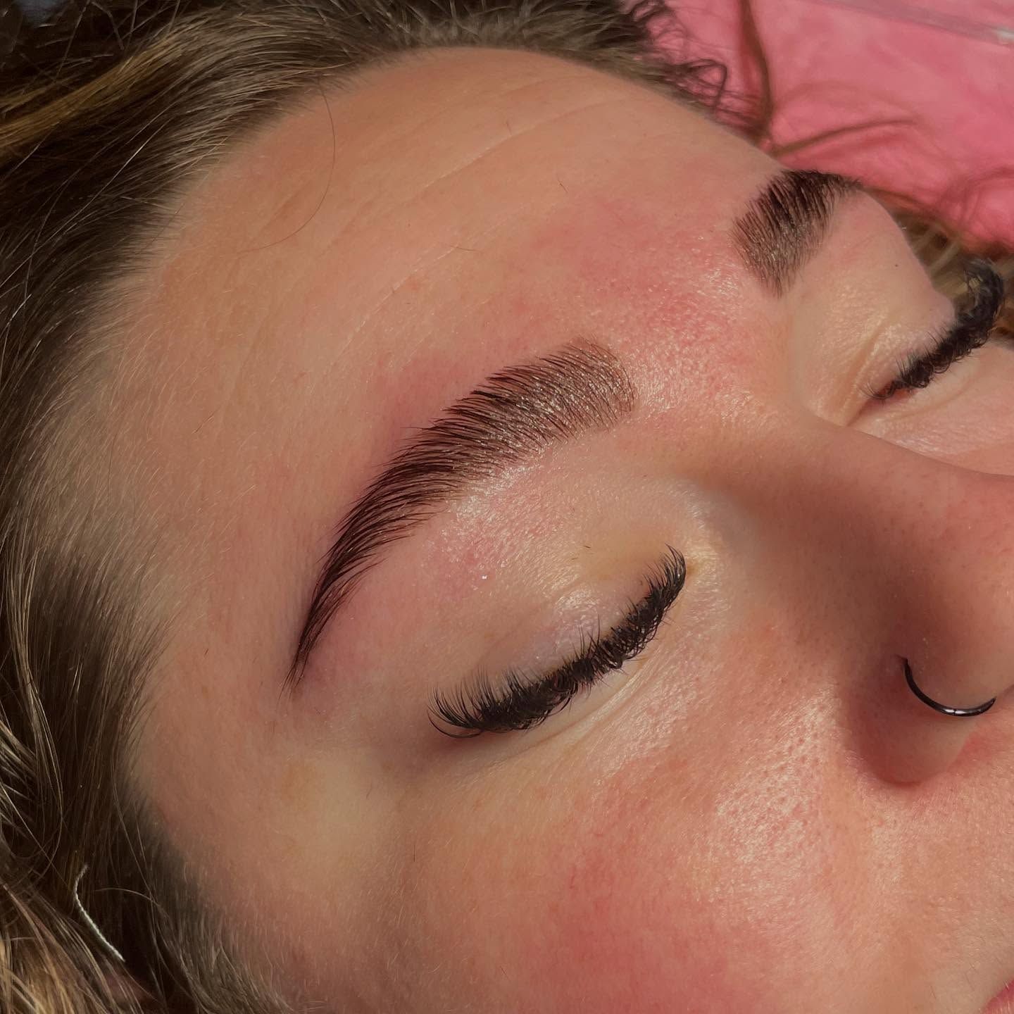 A close up of a woman 's brown eye with long eyelashes.