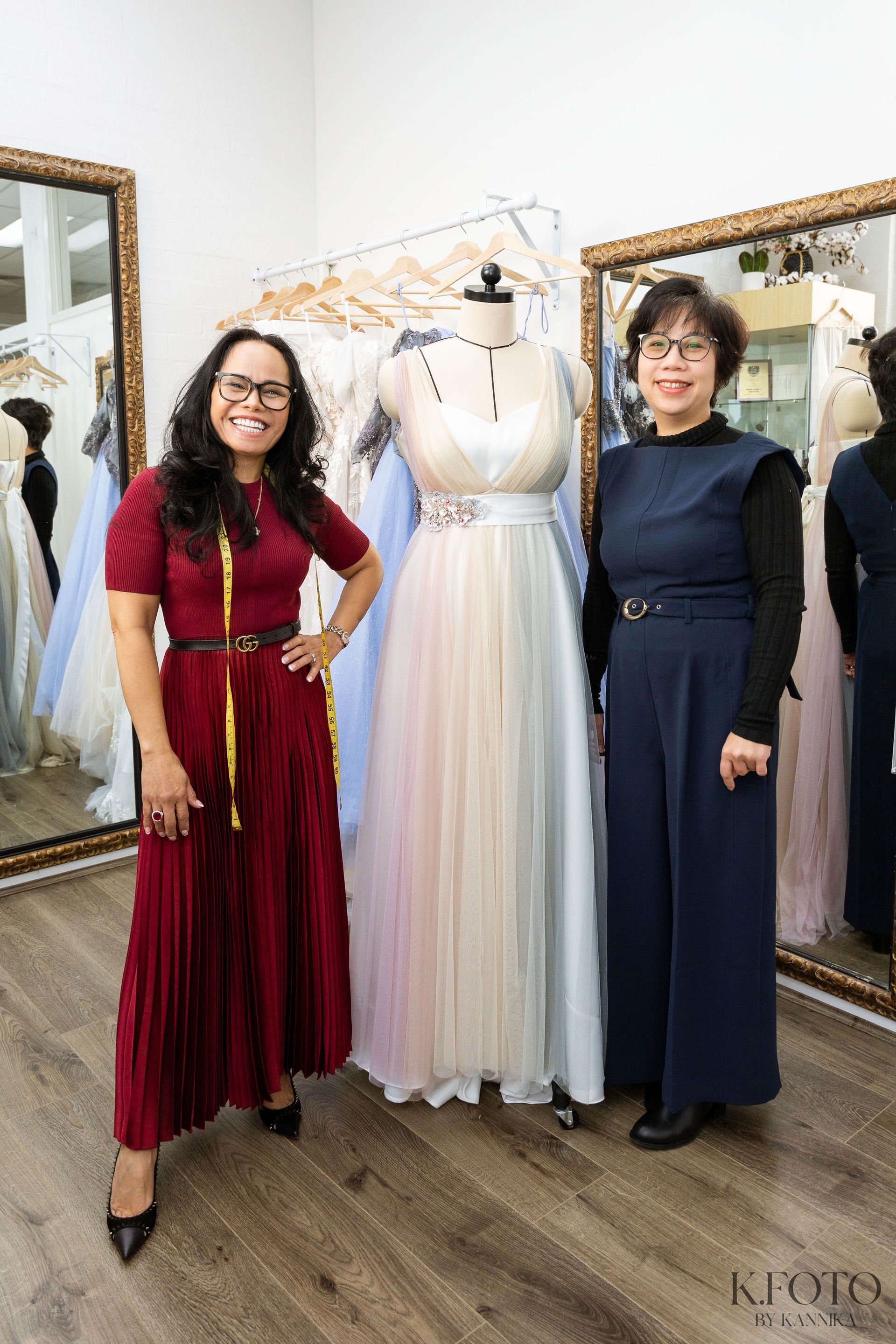 A woman is trying on a wedding dress in front of a mirror.