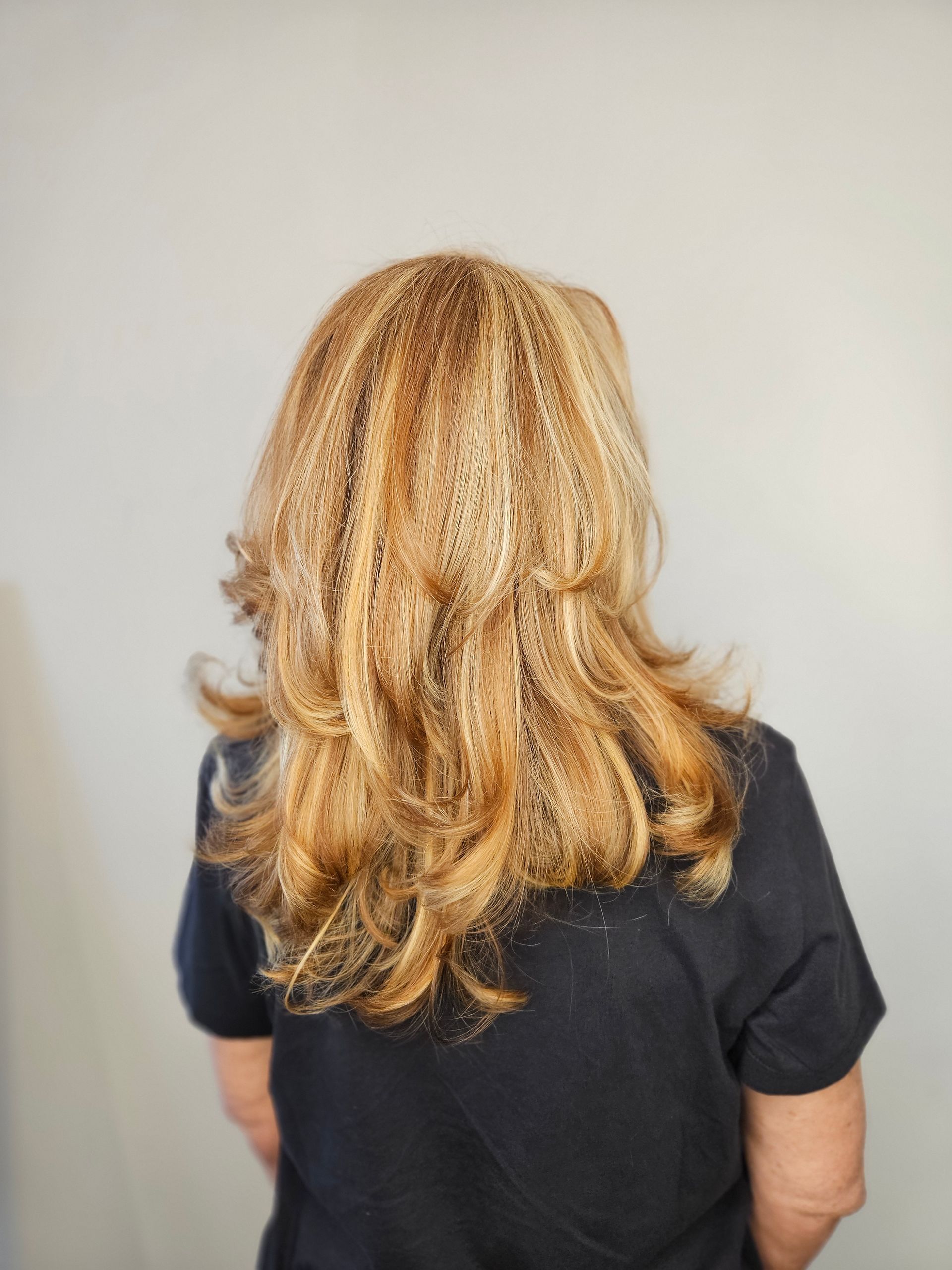 Person getting hair trimmed at the nape of the neck with scissors.