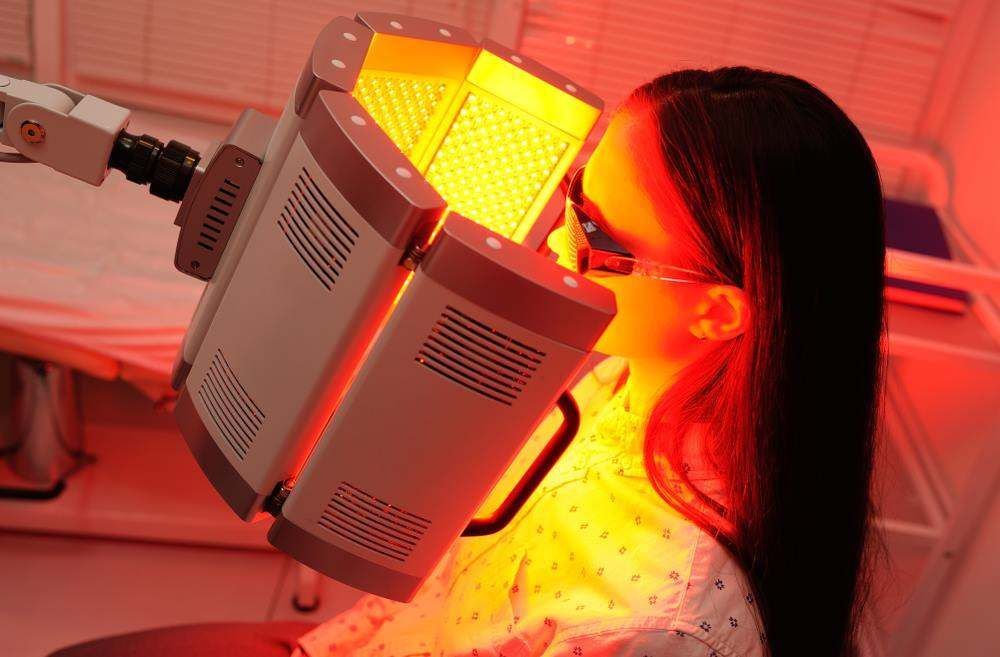 Person Under Red Light Therapy Panel in A Clinic Room — Embrace Cosmetic Clinic in Bundaberg North, QLD