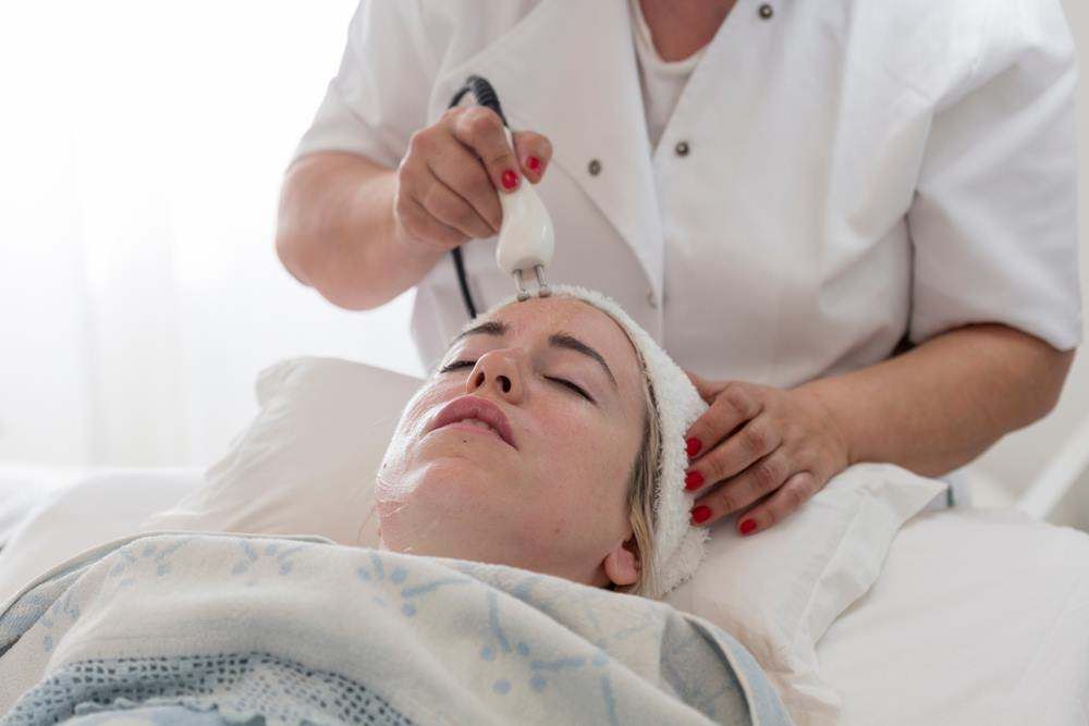 Aesthetic Treatment on A Woman Lying on A Bed — Embrace Cosmetic Clinic in Bundaberg North, QLD