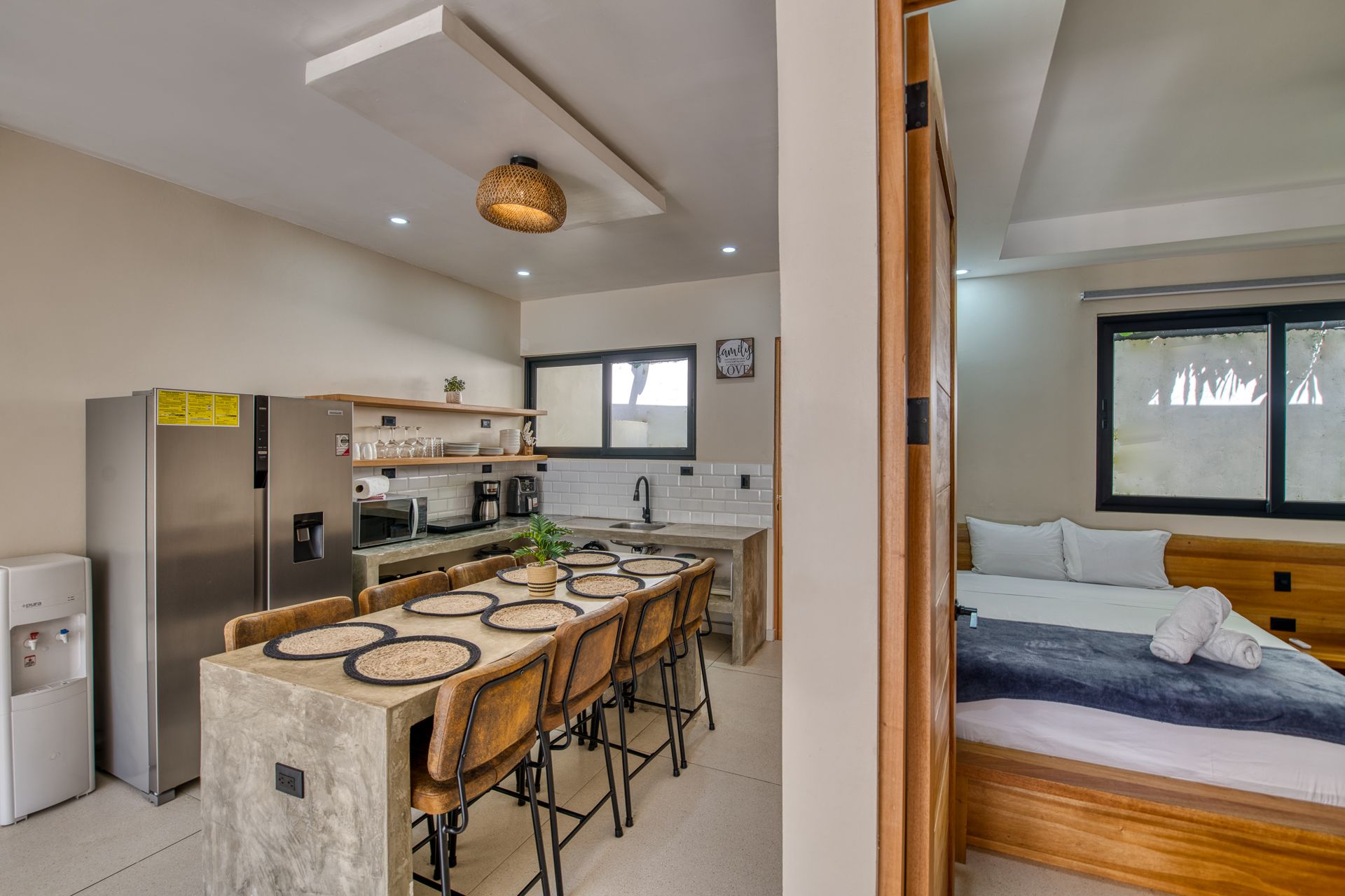 Bedroom with large bed, TV, dresser, closet, and bathroom visible in the background.