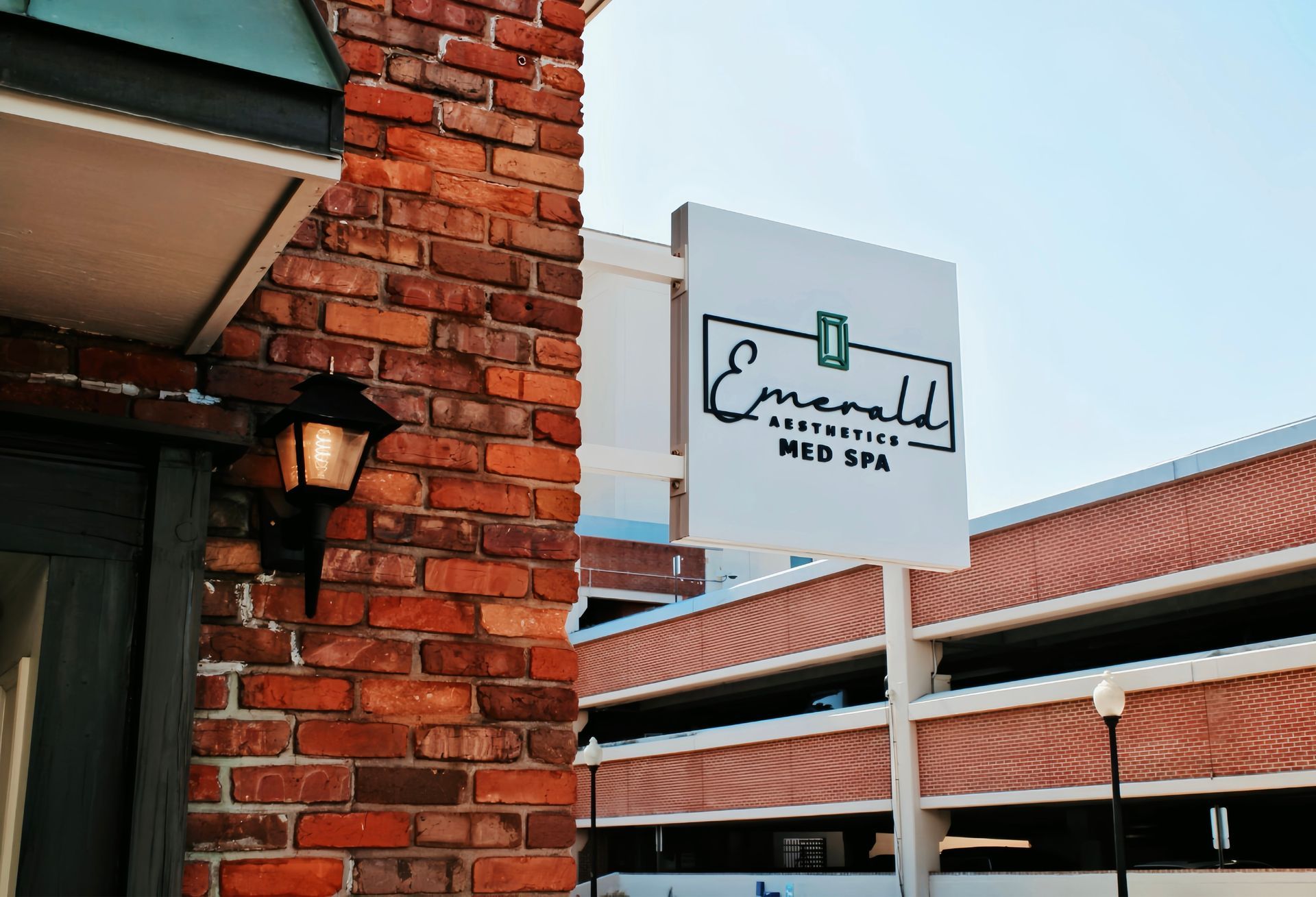 Brick building exterior with a white sign reading “Emerald Spa” and a covered walkway.