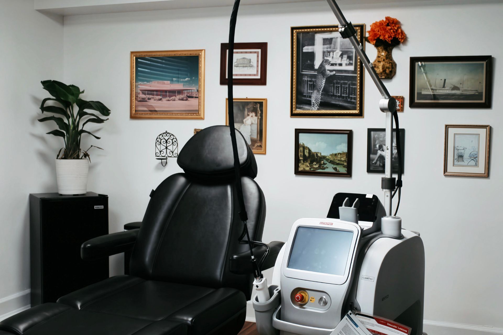 Modern medical office with exam chair, treatment machine, and framed wall art