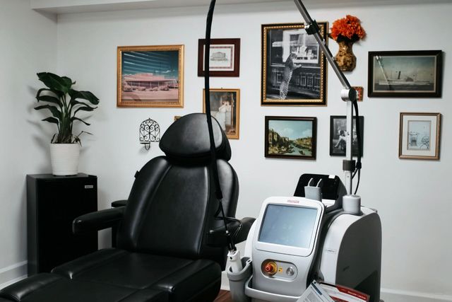 Modern medical office with exam chair, treatment machine, and framed wall art