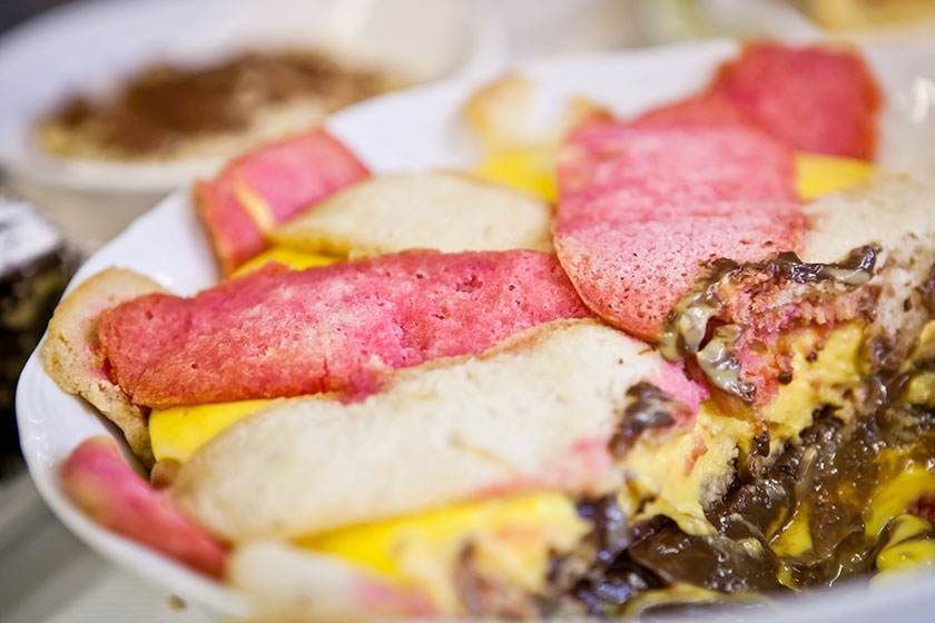 Assiette de saucisses colorées en tranches et d'œufs brouillés sur un plat blanc