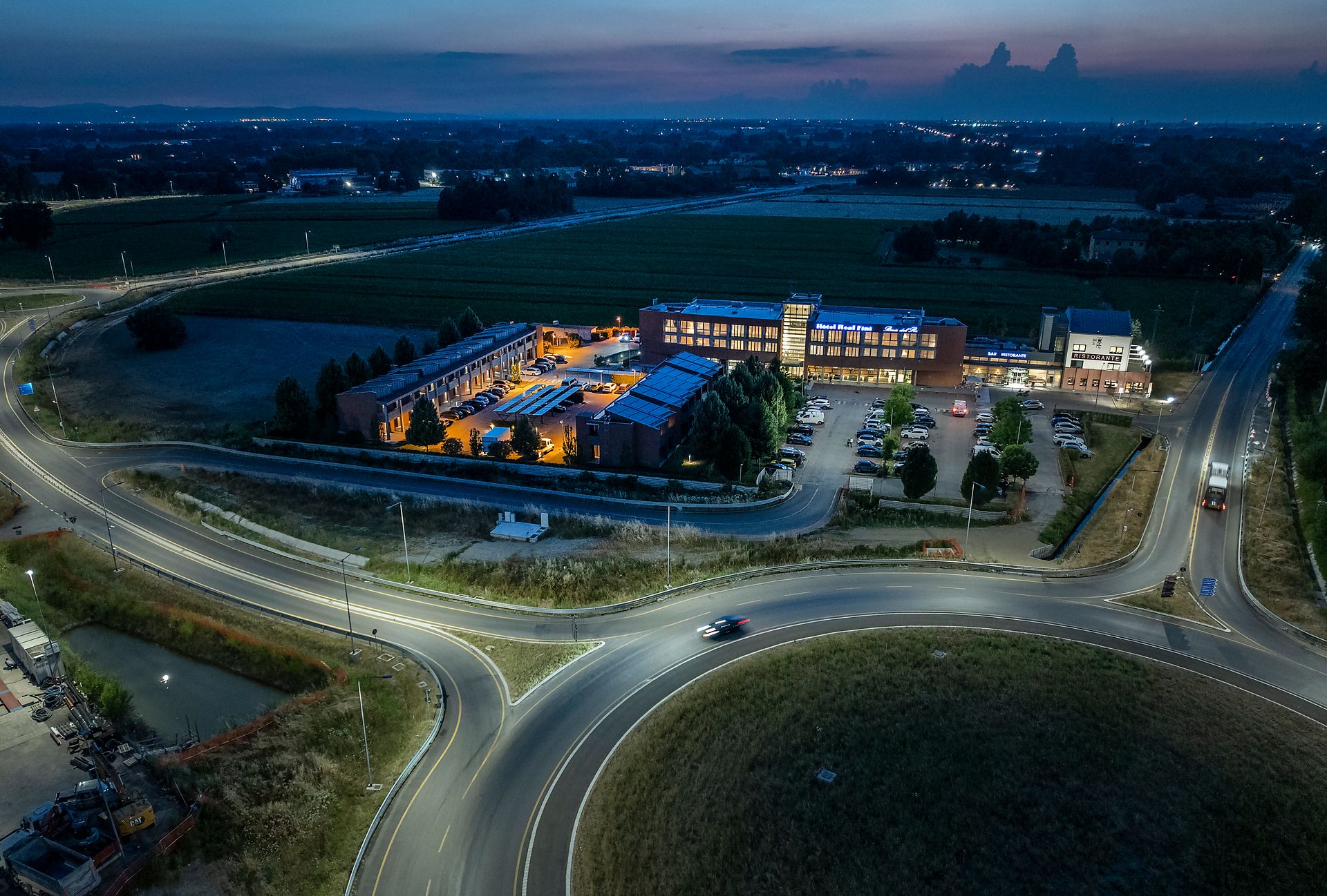 Vue aérienne au crépuscule d'Hotel Real Fini Baia del Re à proximité d'un rond-point et d'une route