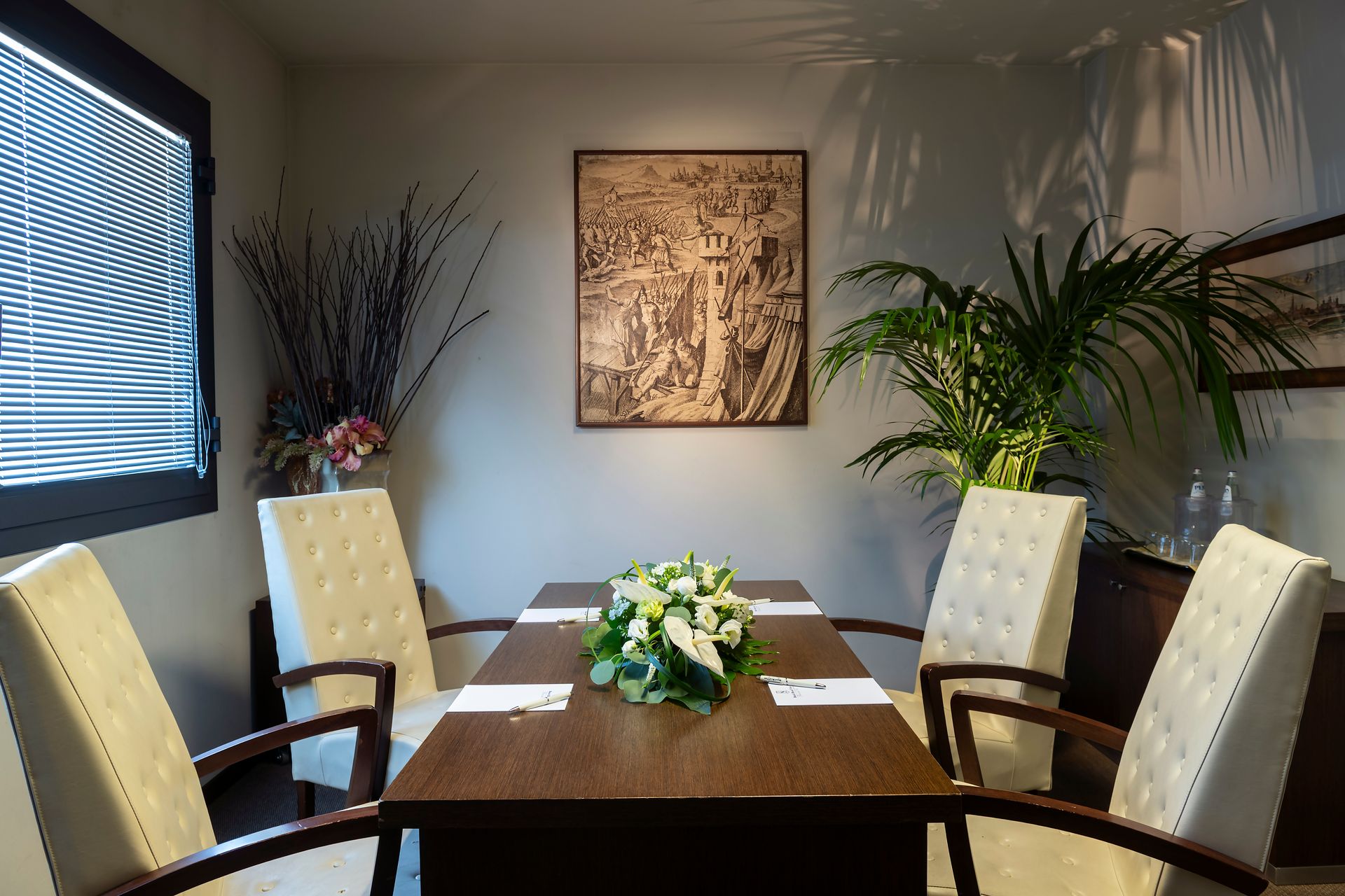Salle de conférence moderne avec une table en bois, des chaises couleur crème, des œuvres d'art murales