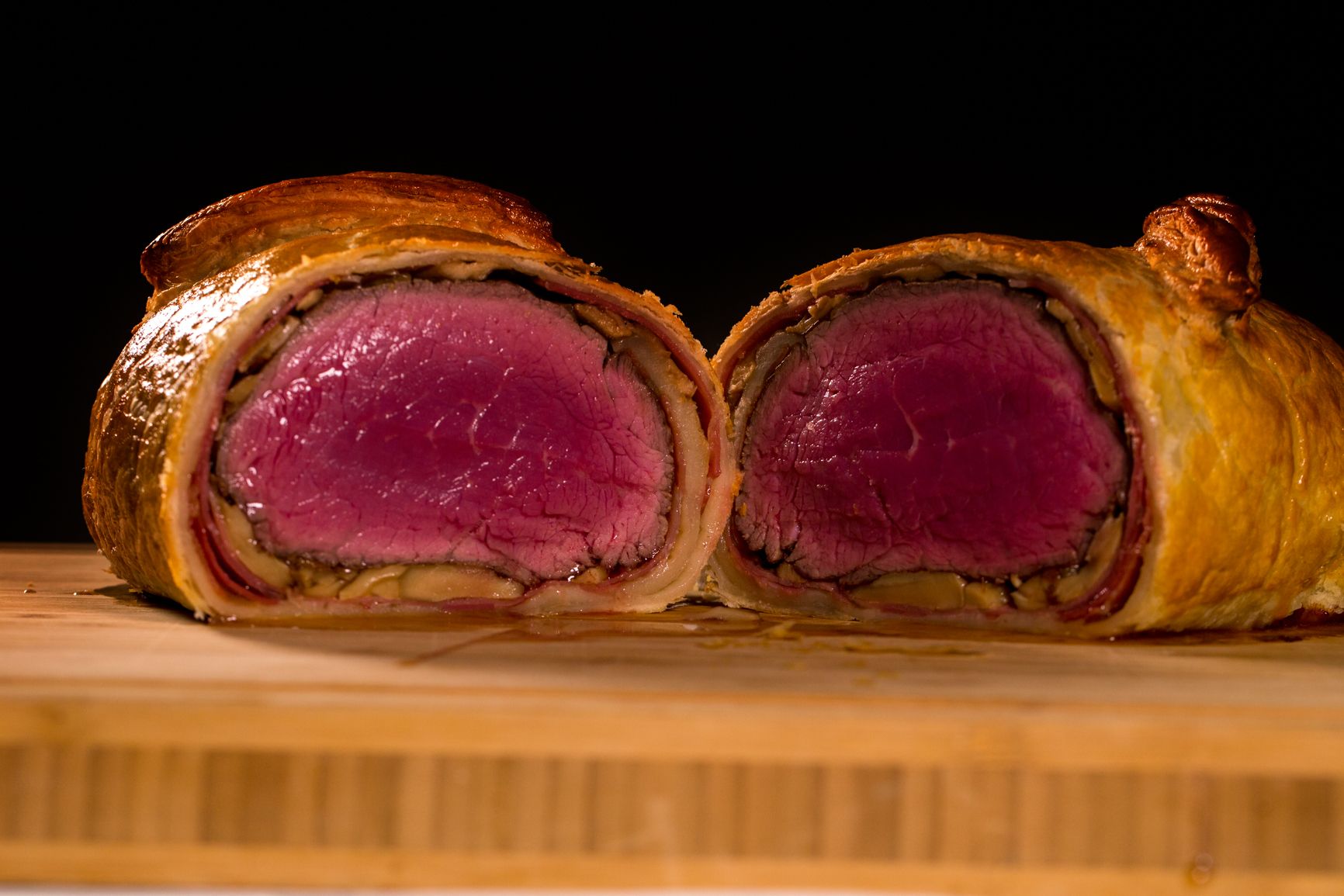 Wellington de bœuf tranché avec cœur rosé sur une planche en bois