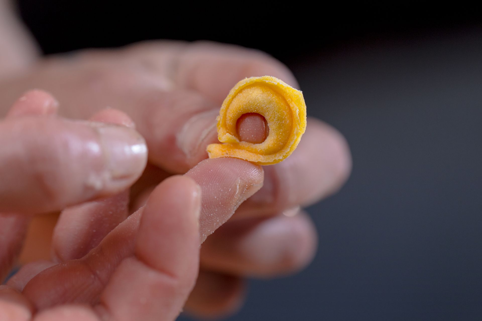Des mains tenant un tortellino