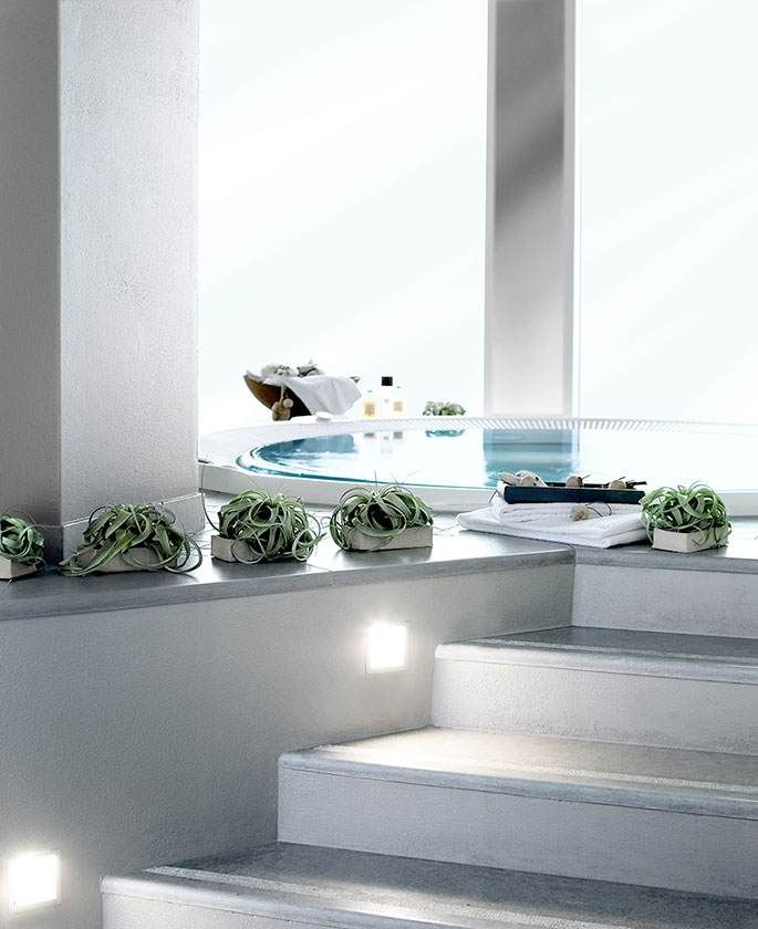Escaliers de spa blancs modernes avec plantes succulentes en pot et applique murale lumineuse dans un cadre