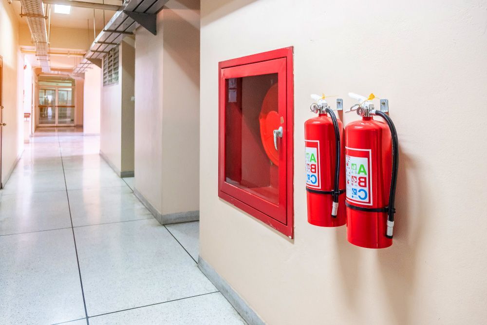 Hallway Wall With Red Fire Hose Cabinet and Two Red Fire Extinguishers — Pasiv Fire in Wollongong, NSW