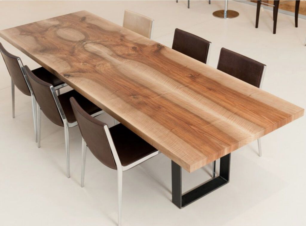 Tavolo da pranzo moderno in legno con sei sedie in una stanza luminosa e minimalista.