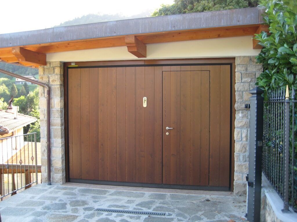 Doppia porta da garage in legno incastonata in una parete esterna in pietra e stucco