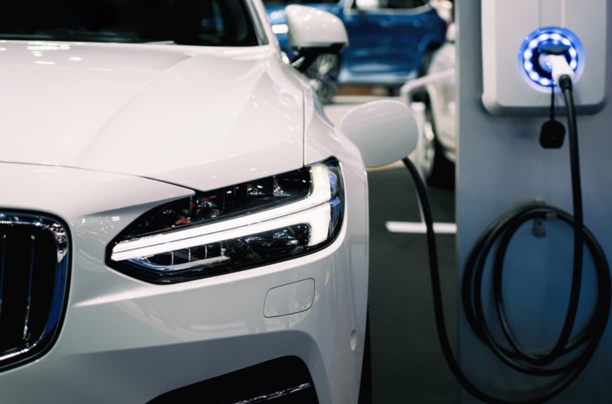 A White Electric Car Is Being Charged At A Charging Station — Ultra Mechanics / EV Drive In Warana, QLD