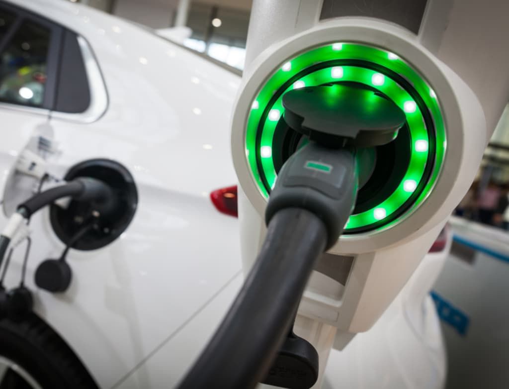 A White Electric Car Is Being Charged At A Charging Station — Ultra Mechanics / EV Drive In Warana, QLD