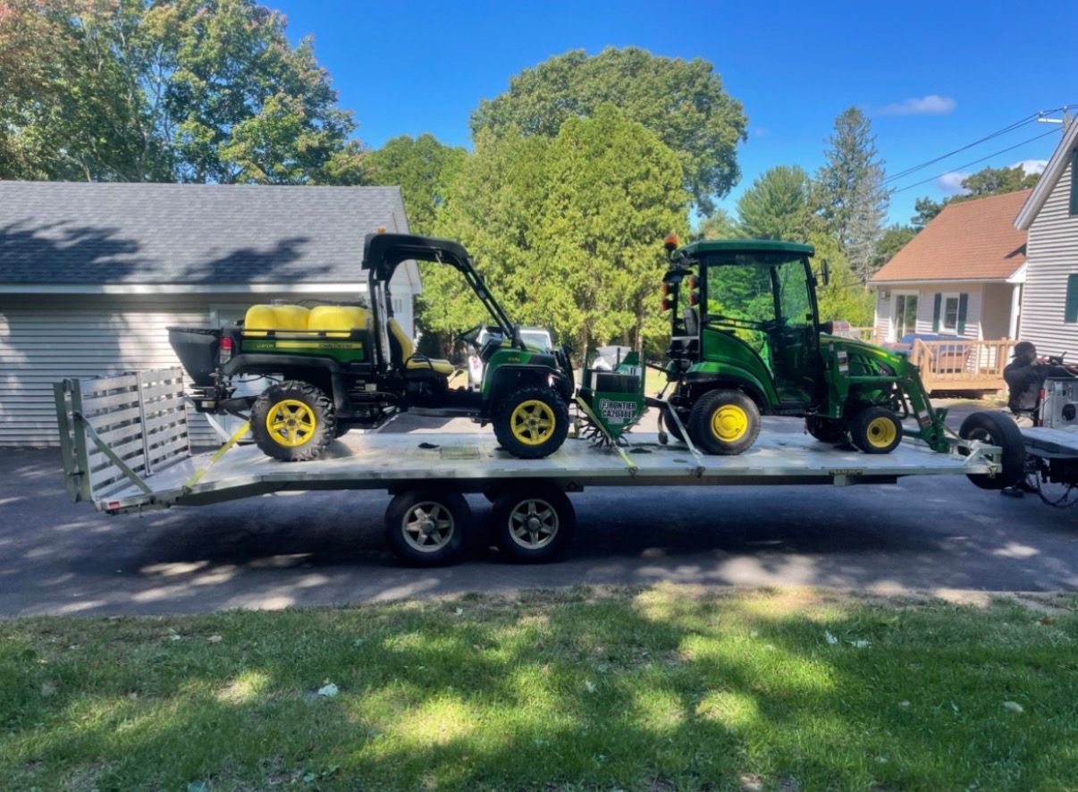 Green lawn dethatcher with a red engine on a grassy lawn.