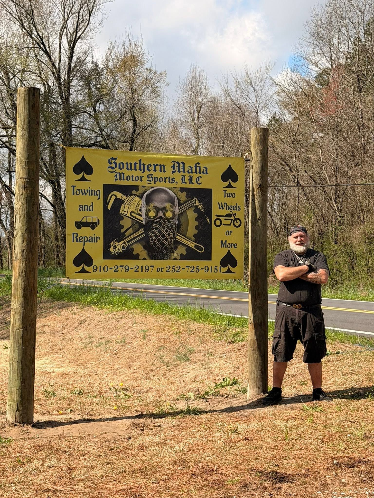 Southern Ohio sign with skull design; person standing beside it in a wooded area