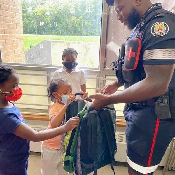 NCO giving youths school bags
