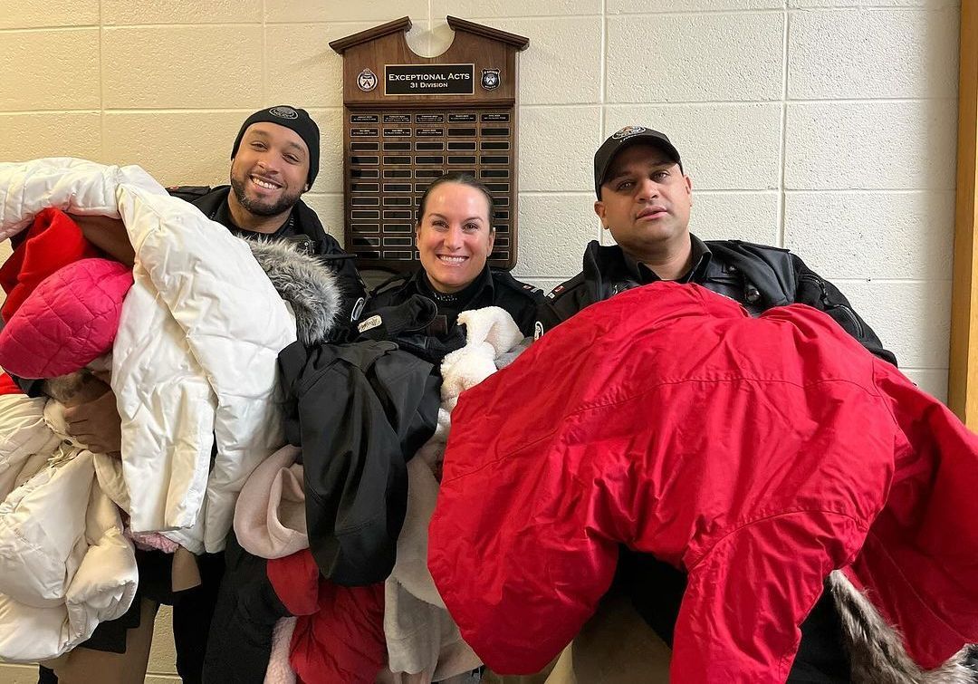 three people holding jackets in front of a plaque that says exceptional acts