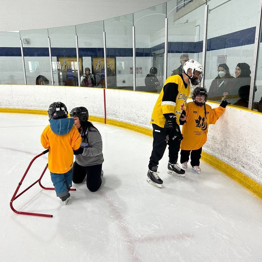 a man and two children are ice skating on a rink