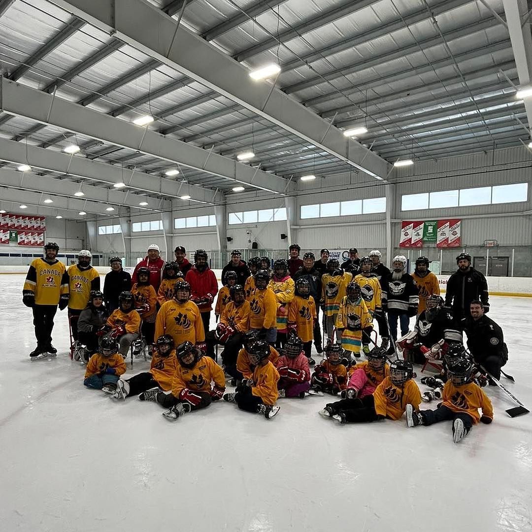 A group of people are posing for a picture on a ice rink.
