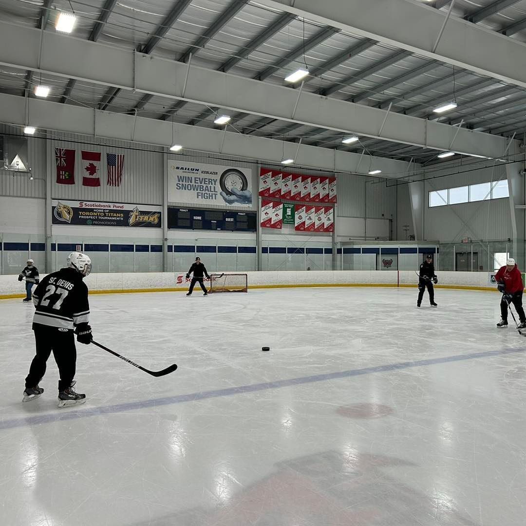 a group of people are playing ice hockey on a rink .