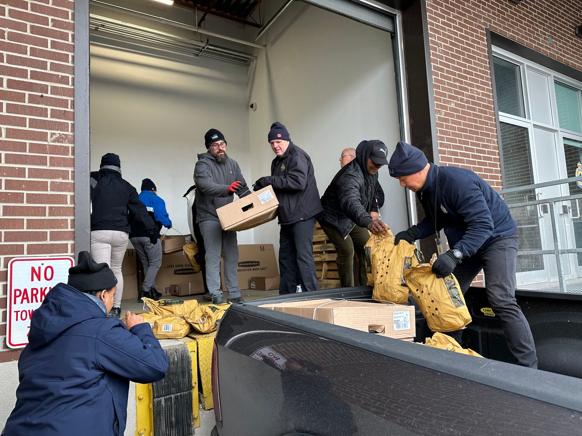 a group of men are loading boxes into a truck