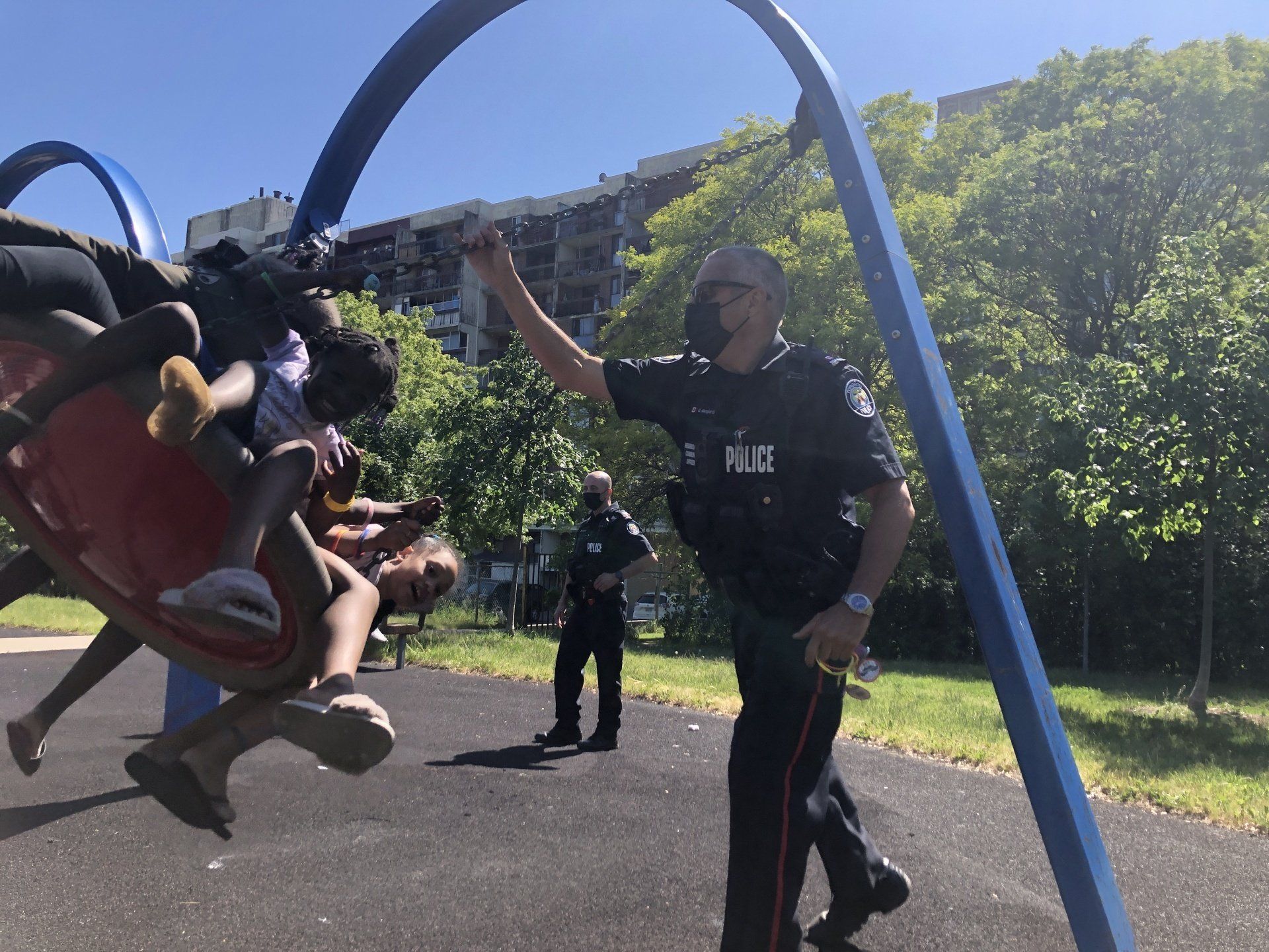 Officers pushing swings